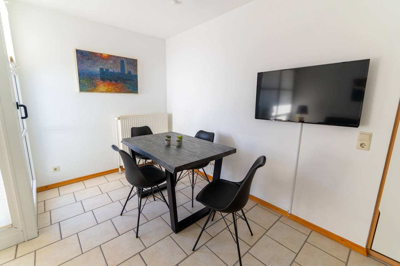 Heller Essplatz mit großem Fernseher und Zugang zum Balkon