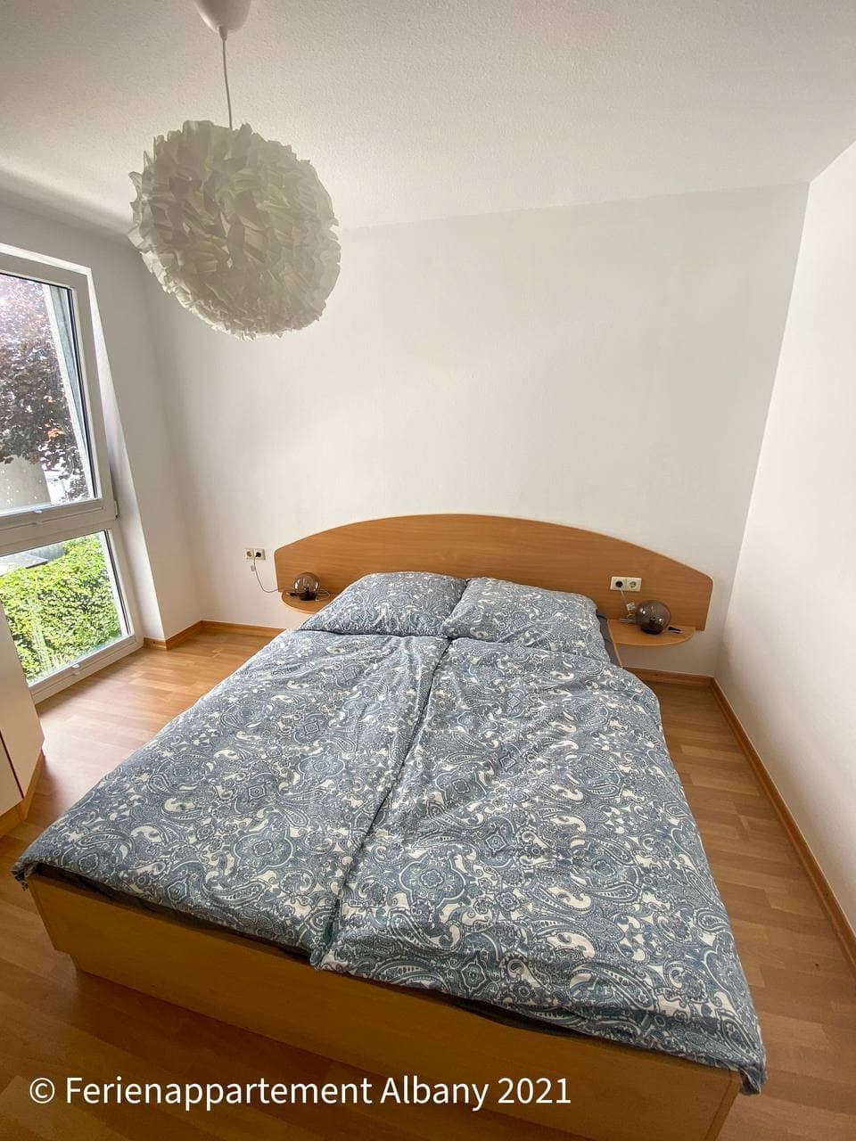 Doppelbett im hellen Schlafzimmer der Ferienwohnung Albany