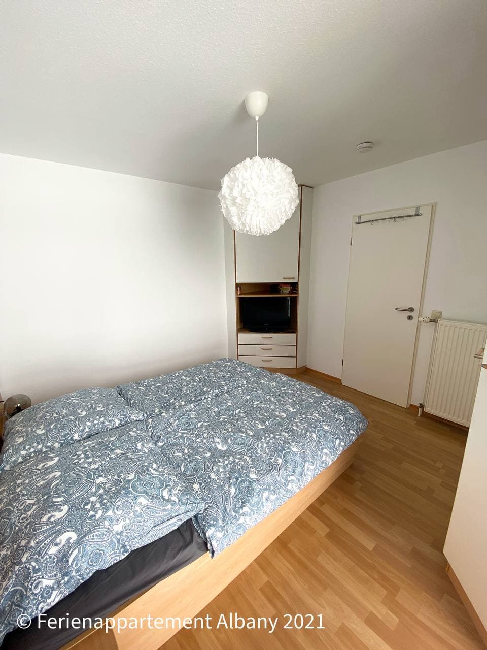 Seitlicher Blick in das Schlafzimmer mit Doppelbett und Stauraum